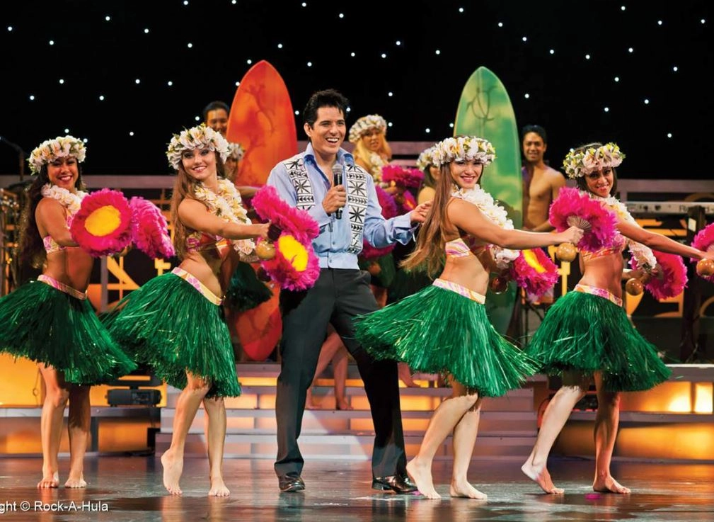 Hula dancers performing with singer on stage