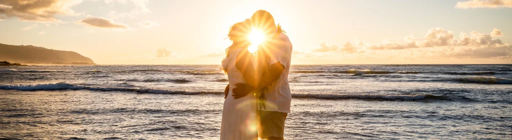 Sunset beach wedding with couple embracing on the shoreline