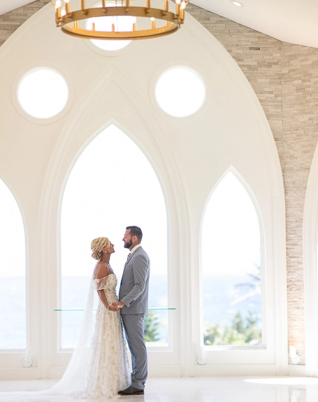 Bride and groom holding hands inside wedding chapel