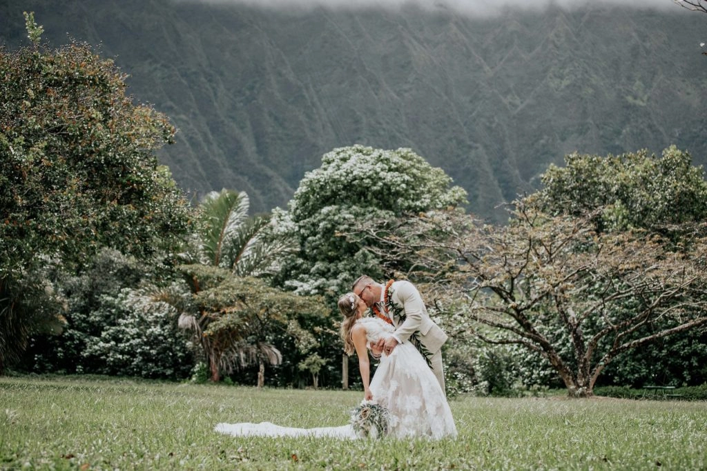 Couple kissing at tropical mountain wedding
